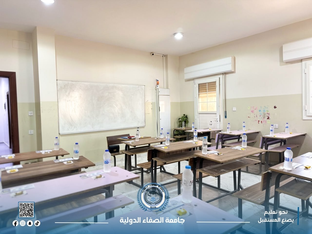 A classroom at Al Safa International University fitted with wooden desks and a whiteboard